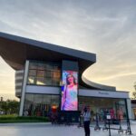 Outlet Store - people walking near brown concrete building during daytime