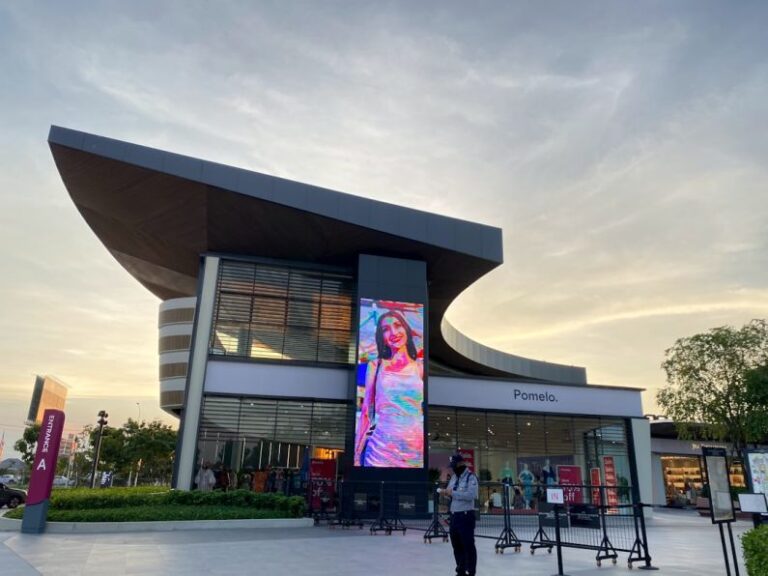 Outlet Store - people walking near brown concrete building during daytime