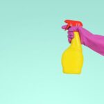 Cleaning Supplies - person holding yellow plastic spray bottle