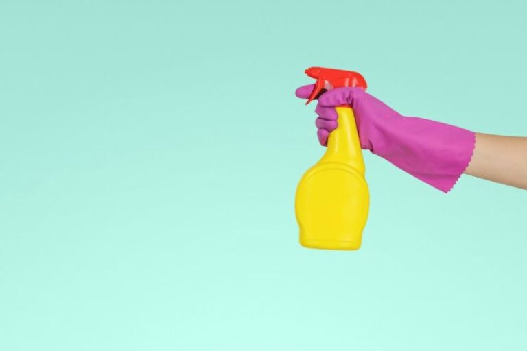 Cleaning Supplies - person holding yellow plastic spray bottle