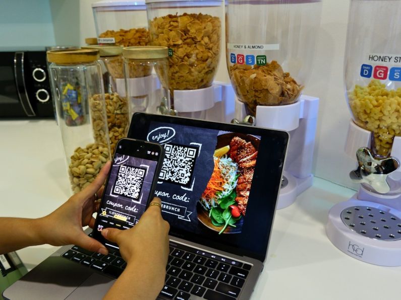 Food Discount - a person using a cell phone and a laptop on a table