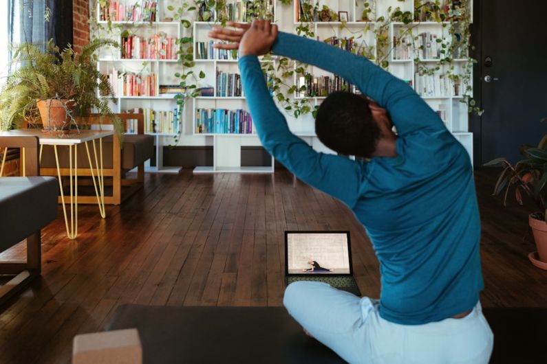 Online Fitness - a man doing yoga in a living room
