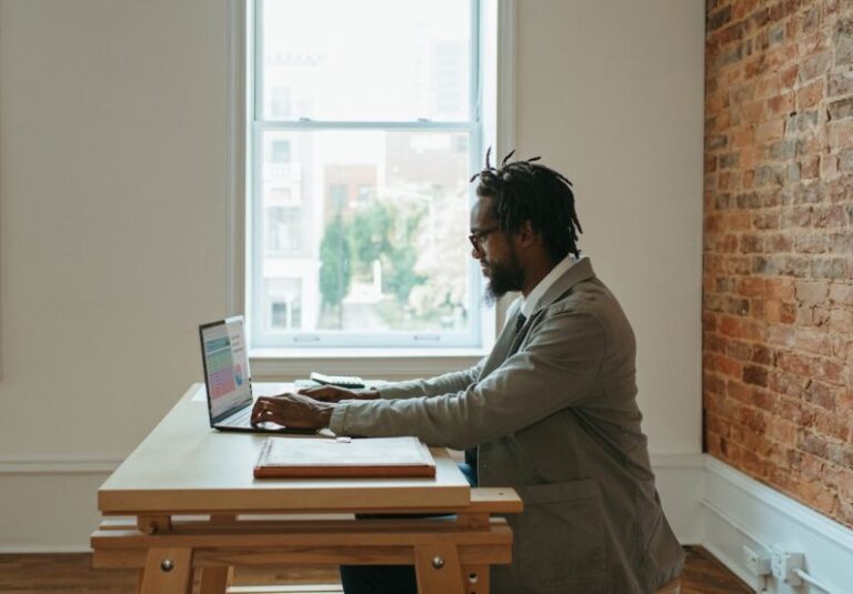 Freelancing - a person sitting at a desk with a laptop and papers