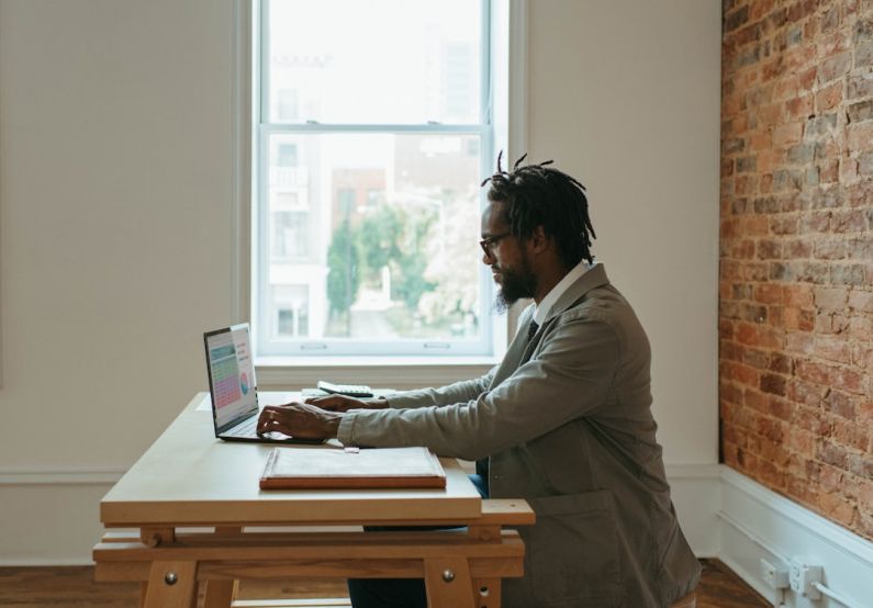 Freelancing - a person sitting at a desk with a laptop and papers