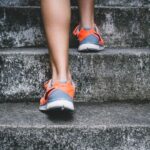 Outdoor Fit - person wearing orange and gray Nike shoes walking on gray concrete stairs