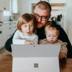 Electronics Home - a man and two children looking at a laptop