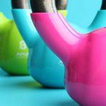 Fitness Equipment - Green, Blue, and Pink Kettle Bells on Blue Surface