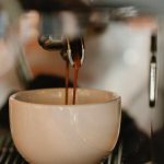 Gourmet Coffee - Modern coffee machine preparing double shot espresso pouring in white ceramic cup in cafe