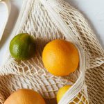 Reduce Debt - Assorted citrus fruits in cotton sack on white surface