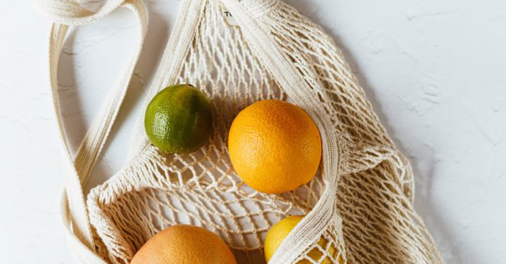 Reduce Debt - Assorted citrus fruits in cotton sack on white surface