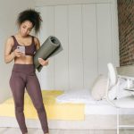 Fitness Wear - Woman in Bedroom Standing while Using Cell Phone