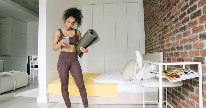 Fitness Wear - Woman in Bedroom Standing while Using Cell Phone