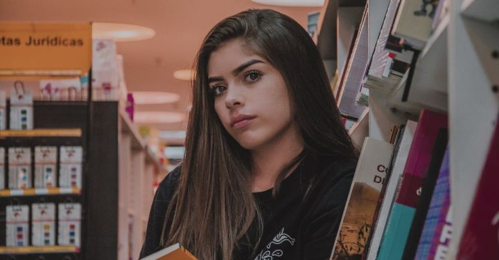 School Shopping - Woman in Black Top Leaning by Bookcase
