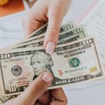 Payday Loans - Hands Exchanging Dollars